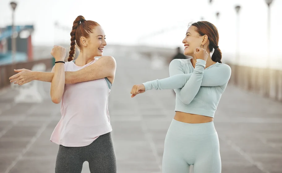 Due ragazze che fanno stretching insieme all'aperto dopo l'allenamento per il defaticamento